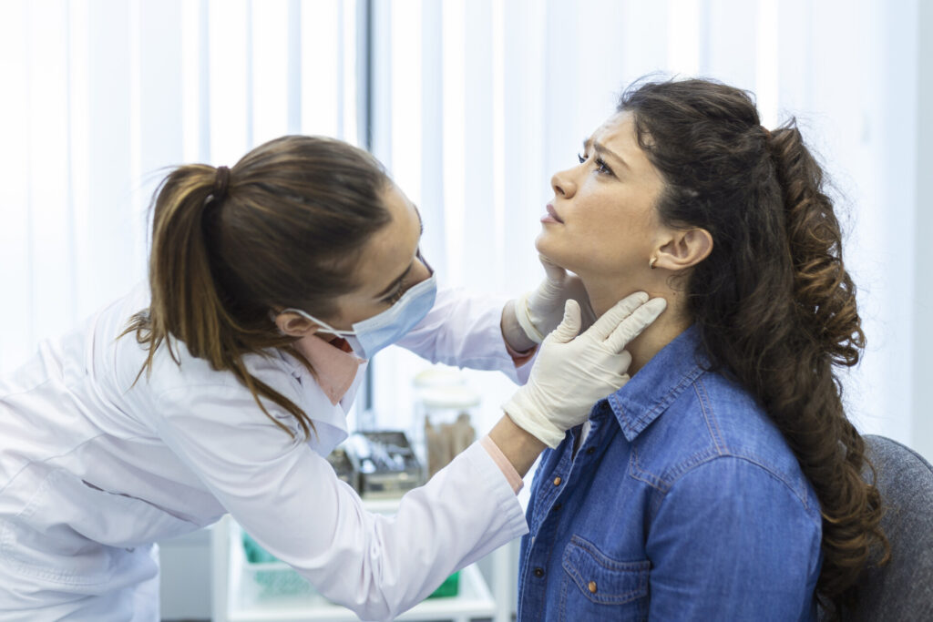 Doctor examining patient's throat in clinic